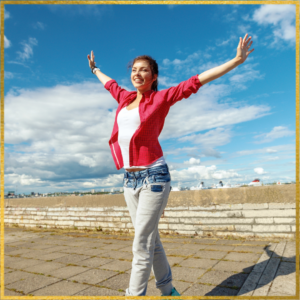 Young lady with a big smile, with her arms in the air, stepping forward.